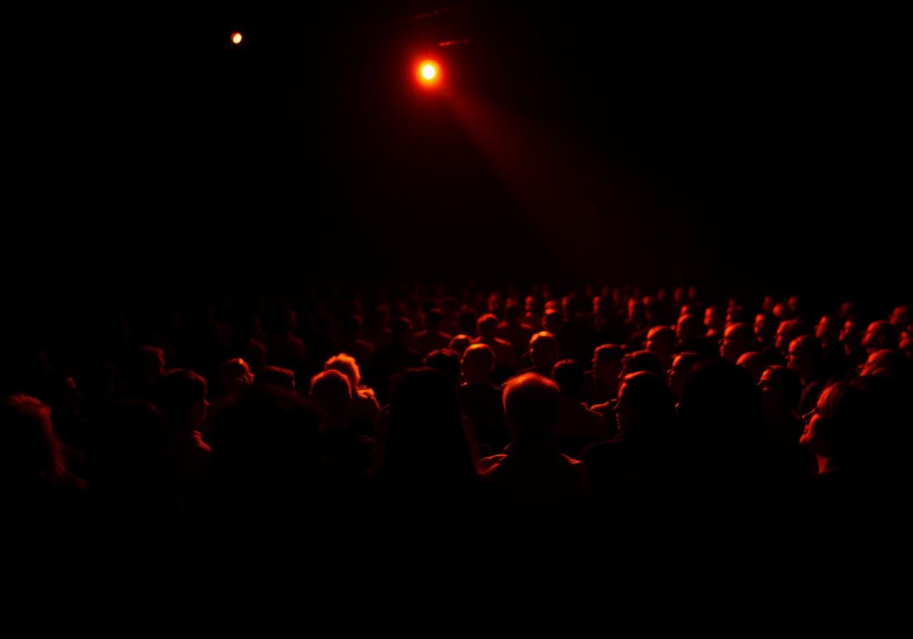 A keynote audience lit by warm stage light
